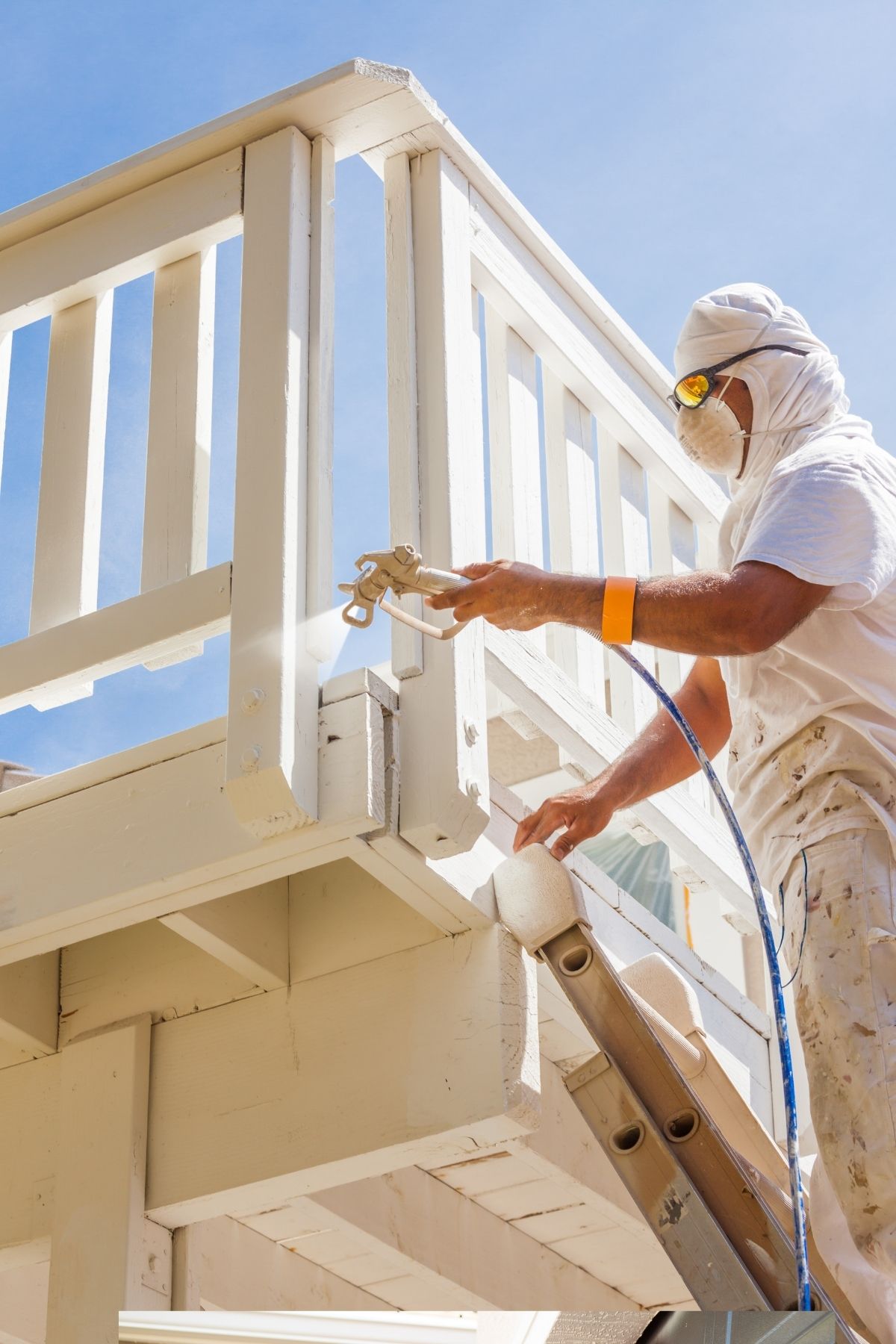 Peintre en bâtiment à La Malbaie appliquant une couche de peinture blanche